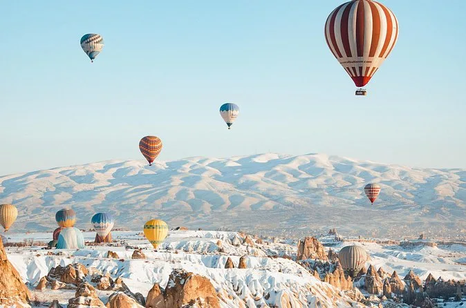 Ballons über schneebedeckten Tälern unter blauem Himmel